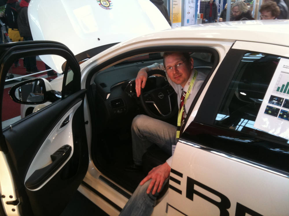 Was zu meiner Vorstellung hier noch gut passt: Wir stellten auf der Messe "New Energy" in Husum am 15.März 2012 unseren ersten Firmen-Ampera neben dem Solar-gedöns aus. Da musste ich gleich posen :-)